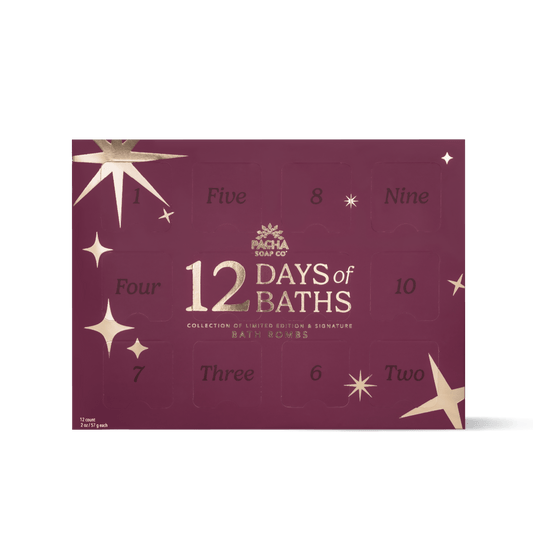 A rectangular bath bomb advent calendar box by Pacha Soap Co. in a deep burgundy color with gold star illustrations and numbered compartments from one to twelve.