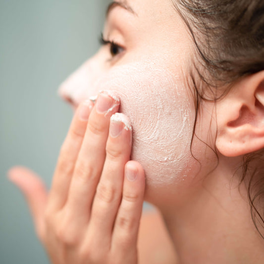 Person applying Lemongrass Peppermint Whipped Soap + Scrub on face