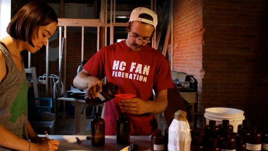 Image of two people making soap using essential oils 