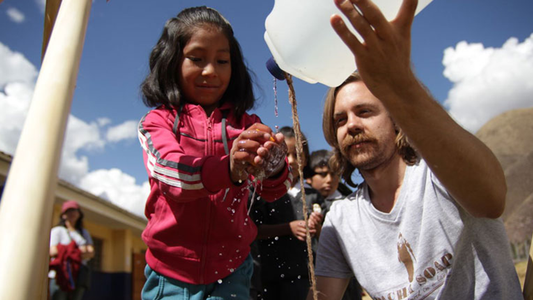 Image of little girl washing her hands with the help of others