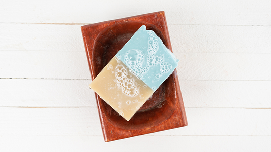 Image of soapy bar soap on soap tray sitting on white table