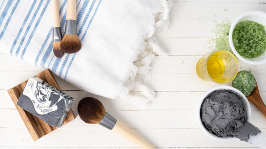 Image of Pacha products next to white and blue towel and makeup brushes
