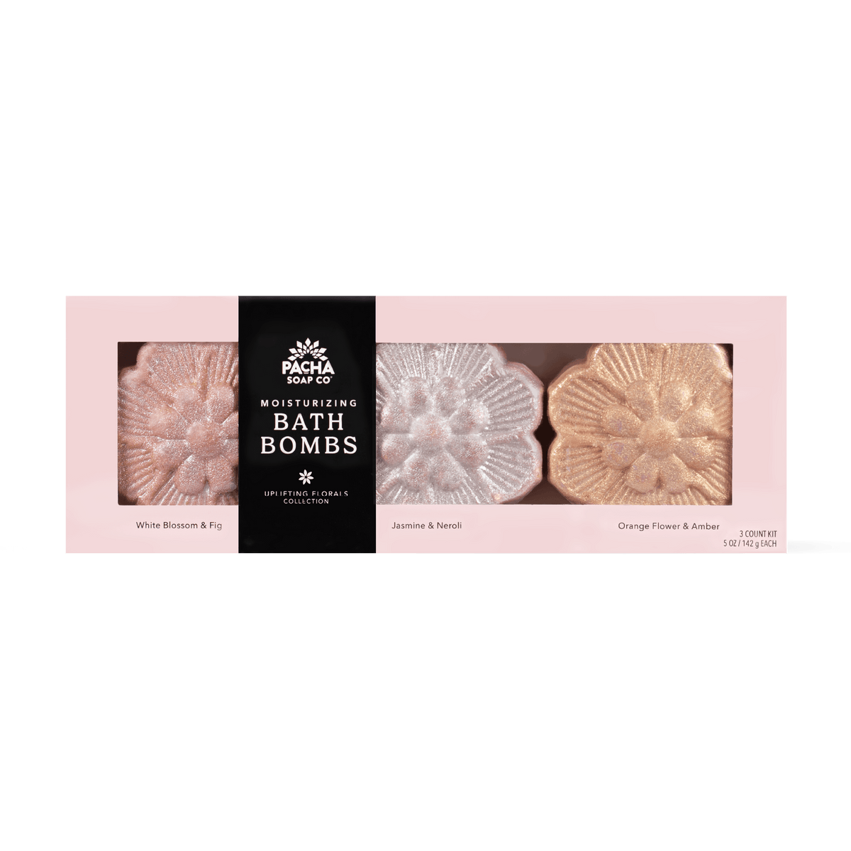 Pacha Soap Co Moisturizing Bath Bombs collection in a pink box with three flower-shaped bath bombs visible through clear windows. The center package is black with white text reading 'PACHA SOAP CO MOISTURIZING BATH BOMBS' and the side packages are pale pink with labels for White Blossom & Fig, Jasmine & Neroli, and Orange Flower & Amber.
