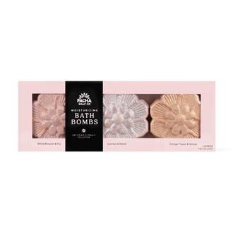 Pacha Soap Co Moisturizing Bath Bombs collection in a pink box with three flower-shaped bath bombs visible through clear windows. The center package is black with white text reading 'PACHA SOAP CO MOISTURIZING BATH BOMBS' and the side packages are pale pink with labels for White Blossom & Fig, Jasmine & Neroli, and Orange Flower & Amber.