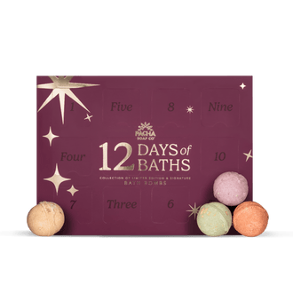 A 12 Days of Baths advent box by Pacha Soap Co. in deep burgundy with gold star and number cutouts, shown with four pastel bath bombs in front on a white background.