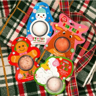 Pacha Soap Kid's Bath bomb cards "FROTHY THE SNOWMAN," "RUDY RED," "SWEET GINGER BREAD," and "SANTA SUDS" all grouped together and on a bright plaid background