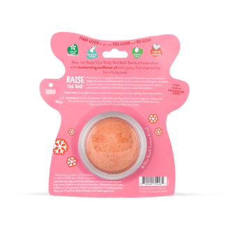 Pacha Soap Kid's Ruby Red Reindeer shaped pink bath bomb card, decorated with colorful snowflakes. This is the back of the card that displays product information such as ingredient lists and product promises. 