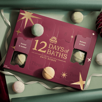 12 Days of Baths Advent Calendar with Handcrafted bathbombs made by Pacha Soap Co in a beautiful setting with bath bombs scattered around it, all along with ornaments and ribbon