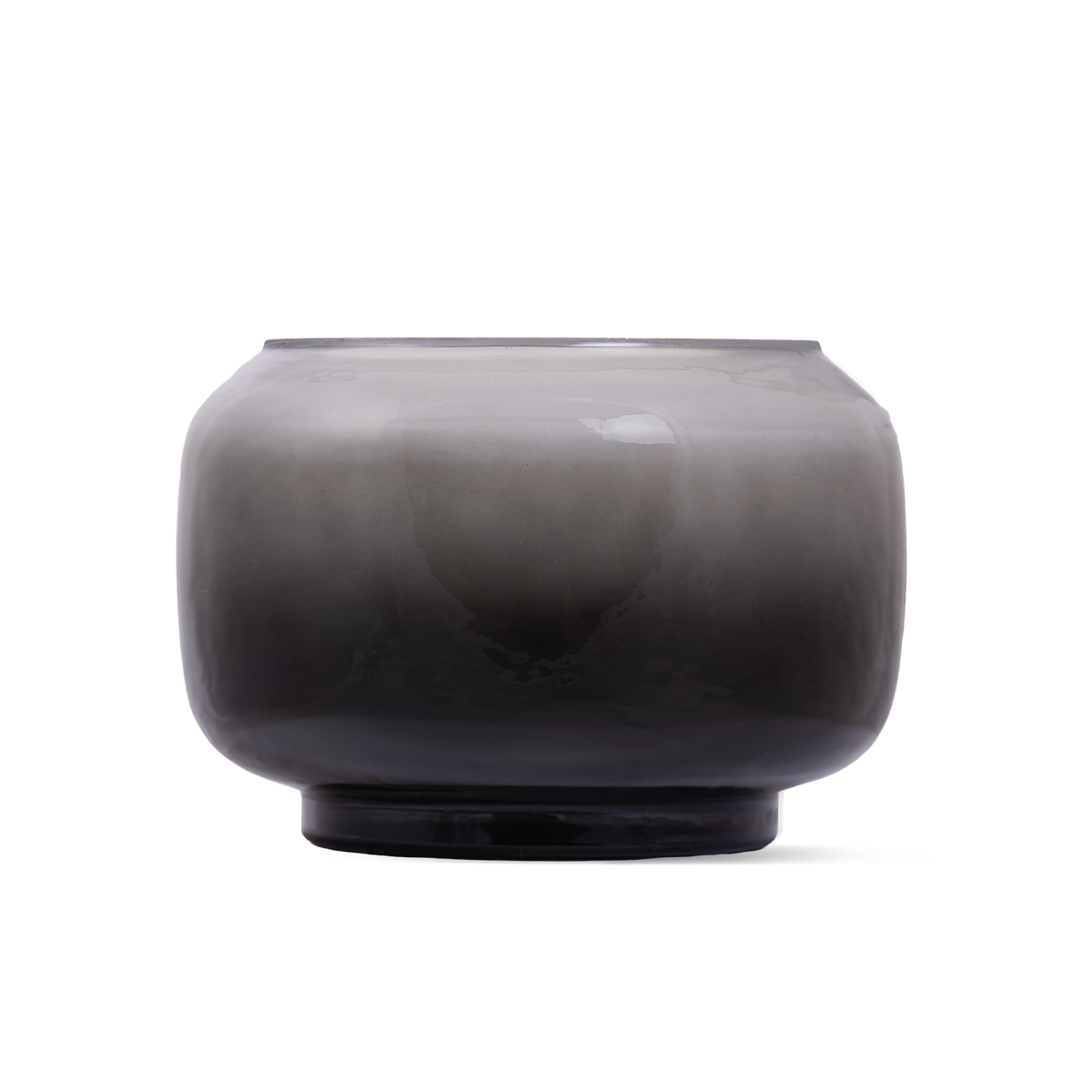 A round, glass candle with a smoky gradient transition from light gray at the top to a deep charcoal black at the base, shown on a plain white background.