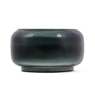 A round, wide-mouthed glass candle featuring a color gradient that transitions from a deep dark green at the top to a translucent light green at the bottom.