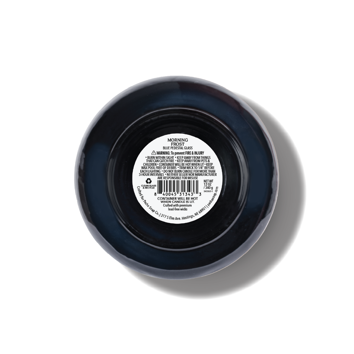 Top-down view of a round blue glass candle with a white product label in the center