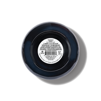 Top-down view of a round blue glass candle with a white product label in the center