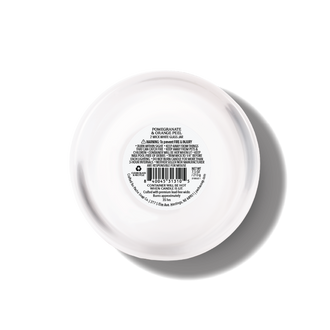 The bottom view of a round white glass jar with printed product information and a barcode